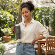Woman holding a insulated tumbler with a scenic background
